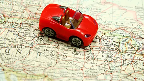 Red toy car on map of the USA